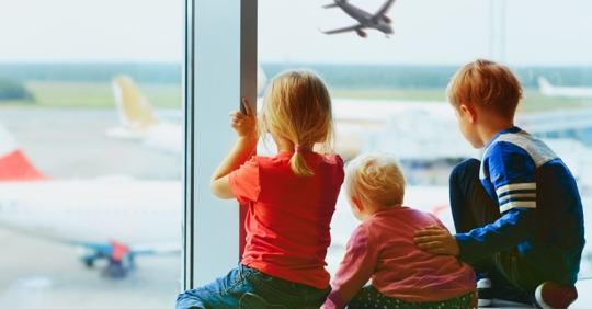 kids looking out the window at plane